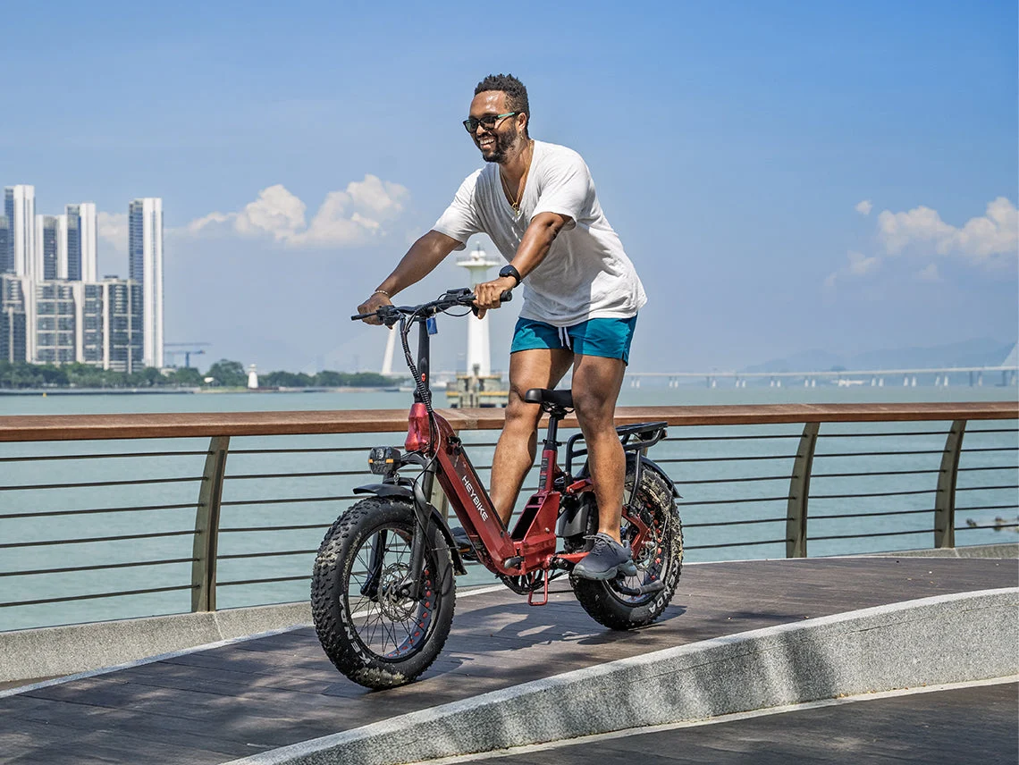 Input photo of a man in a white T-shirt and blue shorts on a bicycle